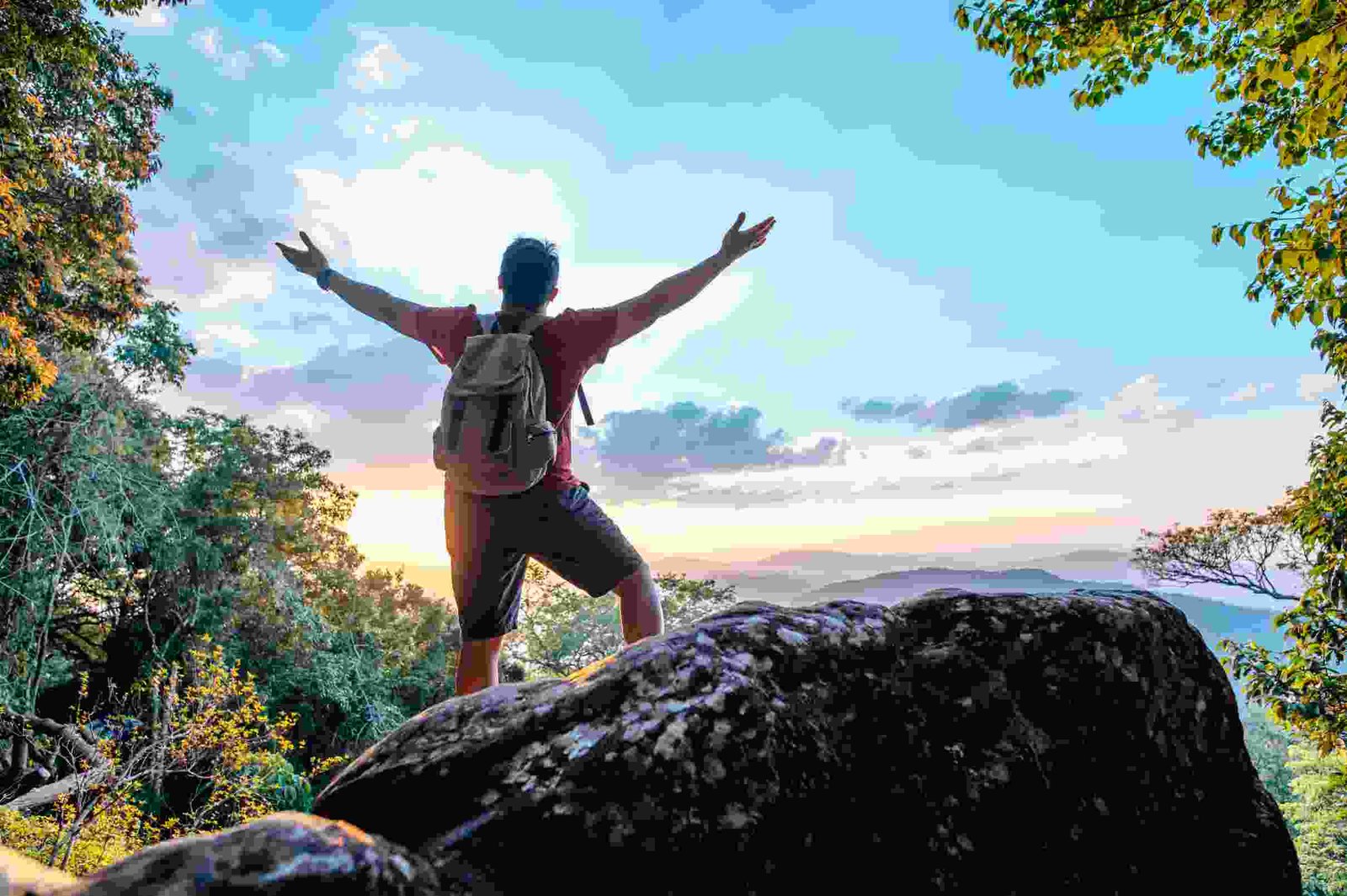 rear view back young asian hiking man standing riseup hands with happy peak rocky mountain copy space (1)